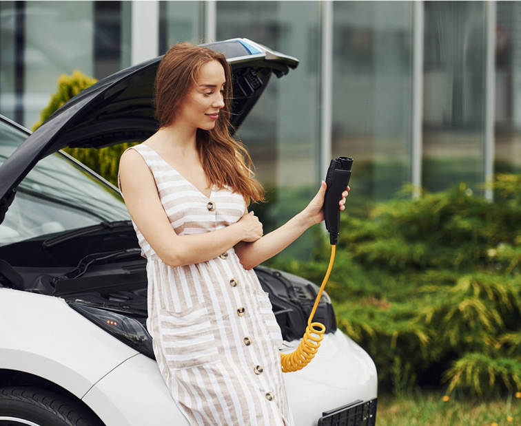 Kobieta trzymająca ładowarkę do auta elektrycznego