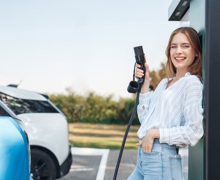 Kobieta trzymająca ładowarkę do auta elektrycznego