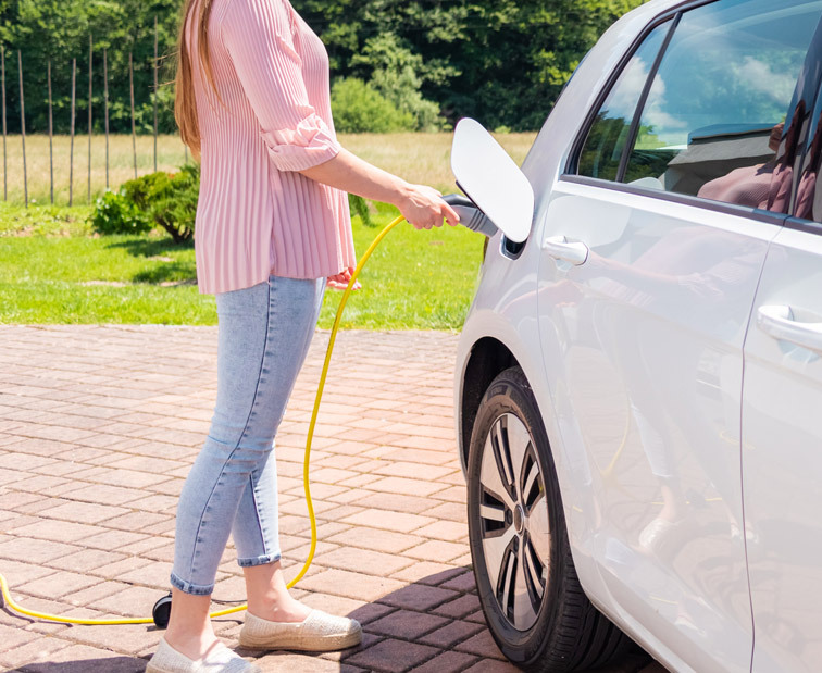 Kobieta ładująca auto elektryczne